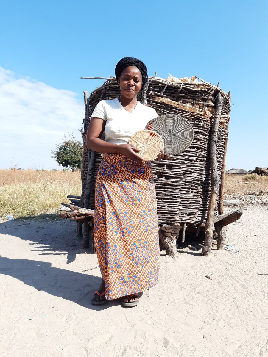 Beya showing us some of the woven wall mats she made through her basket weaving skills Beya showing us some of the woven wall mats she made through her basket weaving skills